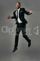 Rising to new heights. Studio portrait of a handsome young businessman against a gray background.