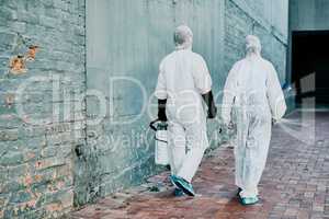 Healthcare workers wearing protective hazmat suits to help prevent the spread of a toxic infection or covid pandemic. First responders cleaning a building for better hygiene and safety