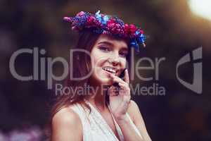 Happiness in her heart and flowers in her hair. Portrait of a beautiful young woman wearing a floral head wreath outdoors.