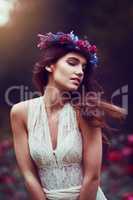 Be as free as you want to be. a beautiful young woman wearing a floral head wreath outdoors.