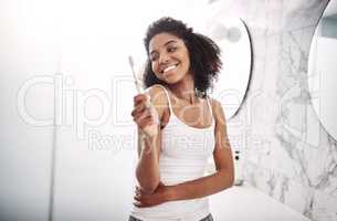 Now I have every reason to smile. Portrait of an attractive young woman brushing her teeth in the bathroom at home.