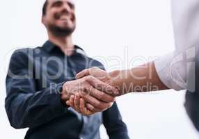 Its the merger their business needed. Closeup shot of two unrecognizable businessmen shaking hands against a white background.