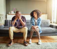 The stress is seeping in today. a stressed out young couple seated on a couch together while contemplating at home during the day.