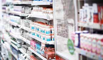 Well find a treatment off our shelf for you. shelves stocked with various medicinal products in a pharmacy.