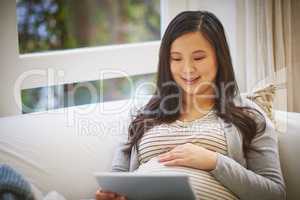 Think Ive found the perfect app for my pregnancy journey. a pregnant woman using a digital tablet at home.