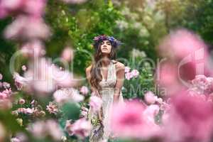 Enjoying the beauty of nature and life. a beautiful young woman wearing a floral head wreath posing in nature.