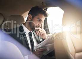 Whats new in the world of business. a handsome young businessman reading the paper while on his morning commute to work.