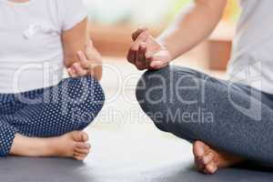 Keep your focus. an unrecognizable woman and little girl doing a yoga pose together while being seated on the floor at home during the day.