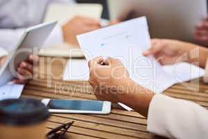 Making sure the paperwork is all in order. an unrecognizable young businesswoman reading paperwork during a meeting in the boardroom.