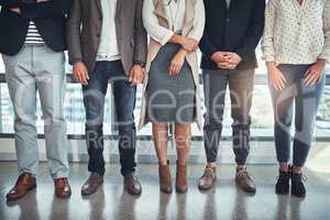 Keep success within your stride. a group of unrecognizable businesspeople standing in line in an office.