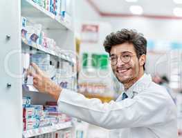 Keeping his shelves well-stocked. Portrait of a pharmacist working in a pharmacy.
