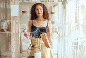 Female entrepreneur, manager or small business owner thinking, deciding and contemplating while filling a bag in a store. African american female shop worker dishing sweets or chocolate in a bag