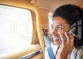 Im right around the corner. an attractive young businesswoman making a phonecall while being driven to work on her morning commute.