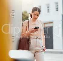 Traveling businesswoman with a phone texting, browsing internet while waiting outside for transport or replying to text while commuting to work. Young worker booking online transport service in city