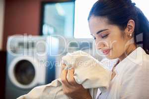 I love it when my linen is all clean. an attractive young woman doing laundry at home.