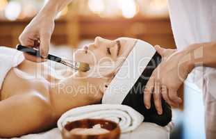 Time for a bit of a beauty booster. an attractive young woman getting a facial at a beauty spa.
