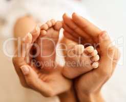 The tiny feet that made her life complete. a mother gently holding her babys feet.