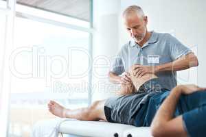 Were going to take recovery one step at a time. a handsome mature male physiotherapist treating an unrecognizable patient.