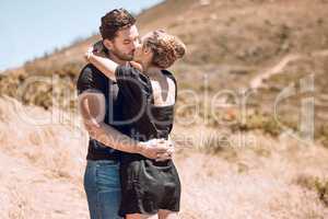 Kissing, relaxed and romantic couple enjoying love, bonding and break on getaway together on a sunny day outdoors. Boyfriend and girlfriend in a loving relationship on honeymoon, holiday and date