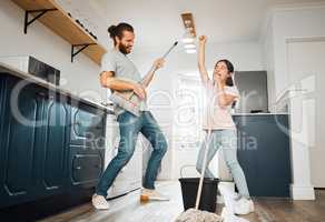 Having fun doing chores, dancing and singing father and daughter cleaning the living room together at home. Carefree, happy and cheerful parent bonding, doing housework and playing with little girl