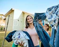 My family deserves clean clothes everyday. Portrait of a mother and daughter hanging up laundry together outside.