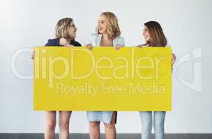 Yellow, the color of happiness. Studio shot of a group of businesswomen holding up a blank yellow placard.