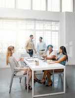 Corporate, professional and serious business people talking in meeting, discussing and making conversation in a modern office together at work. DIverse, young and concentrated colleagues planning