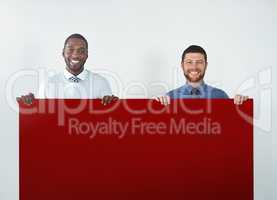 We knew this color would grab your attention. Studio shot of two businessmen holding up a blank red placard.