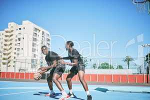 Basketball, sports and game between sporty male players having fun while playing on a court outdoors. Young black friends training and being active together while competing in a competitive sport
