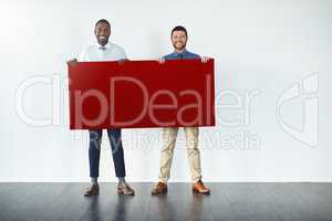 Might we recommend some red for your message. Studio shot of two businessmen holding up a blank red placard.