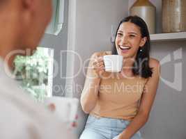 Happy, carefree and laughing woman drinking coffee in the morning and having fun with her boyfriend at home. Young and excited female laughs at a funny joke while and enjoying time with her partner