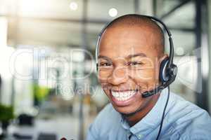 Supporting the customer with one smile at a time. a young handsome male customer support agent working in the office.