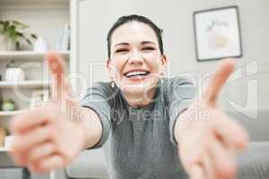 Happy, smiling and laughing woman reaching out her arms for a hug, embrace or holding while relaxing alone at home. Portrait of a relaxed, content and cheerful female giving embrace and being playful