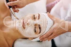 I can already feel it tingling. an attractive young woman getting a facial at a beauty spa.