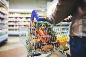 Her grocery store of choice. a woman pushing a trolley while shopping at a grocery store.