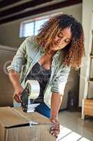 Im putting you away until I need you again. a confident young woman taping a box closed to put it away in storage after moving into a new home.