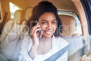 I always arrive in style. Portrait of an attractive young businesswoman making a phonecall while being driven to work on her morning commute.