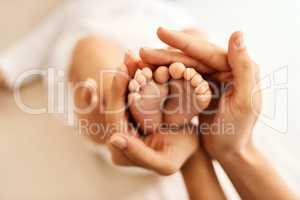 Nothing more sweet than tiny baby feet. a mother gently holding her babys feet.