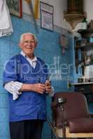 Being a barber is taking care of the people. a senior man in his barber shop.