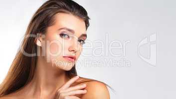 The face of feminine confidence. Studio portrait of a beautiful young woman posing against a grey background.