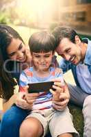 I like this one. a happy young family of three taking selfies white sitting in the backyard.