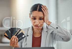 Finance, debt and credit with a business woman suffering from worry, stress and anxiety of inflation in the economy. Young female holding bank cards and having problems while trying to pay an account