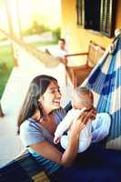 Youre growing up so quickly. a cheerful young mother holding her baby infant son while smiling at him outside at home.