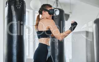 Female boxer using VR goggles to train, exercise and stay fit and healthy in a modern fitness gym. Sporty, exercising and wellness expert or fighter training using a 3d virtual reality metaverse game
