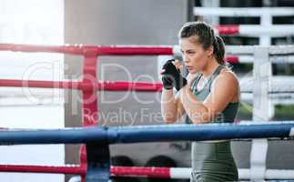 Boxing, fist and athletic woman uses the gym to practice her speed. Focused, powerful and strong lady that is active and sporty. Fit female training in the fighting ring to prepare for a match.