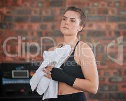 Sweaty, active sports woman taking break from a training workout session, exercising or boxing in gym with sportswear. Strong, healthy and athletic woman wiping sweat with towel at a wellness center