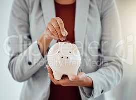 Banking, finance and money in piggybank for savings, investment and growth for business woman. Closeup of hands of a corporate professional putting coins into a tool to save, insurance and security