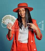 Rich young woman holding cash, competition or lottery winnings pointing looking stylish, elegant and trendy. Happy, excited and celebrating female cheering with income, savings or investment returns