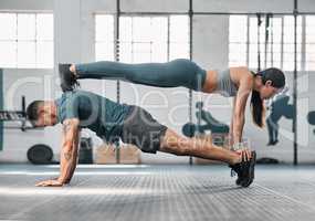 Strength, active and fit couple exercising, training or doing workout exercise routine inside gym or sports center. Athletic, fitness man and woman balancing together in a physical endurance session