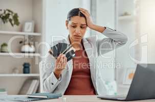 Financial stress, concerned and frustrated woman holding bank cards in her hand at her desk. Business female worried about economic decisions, credit interest or loan and debt in money crisis.